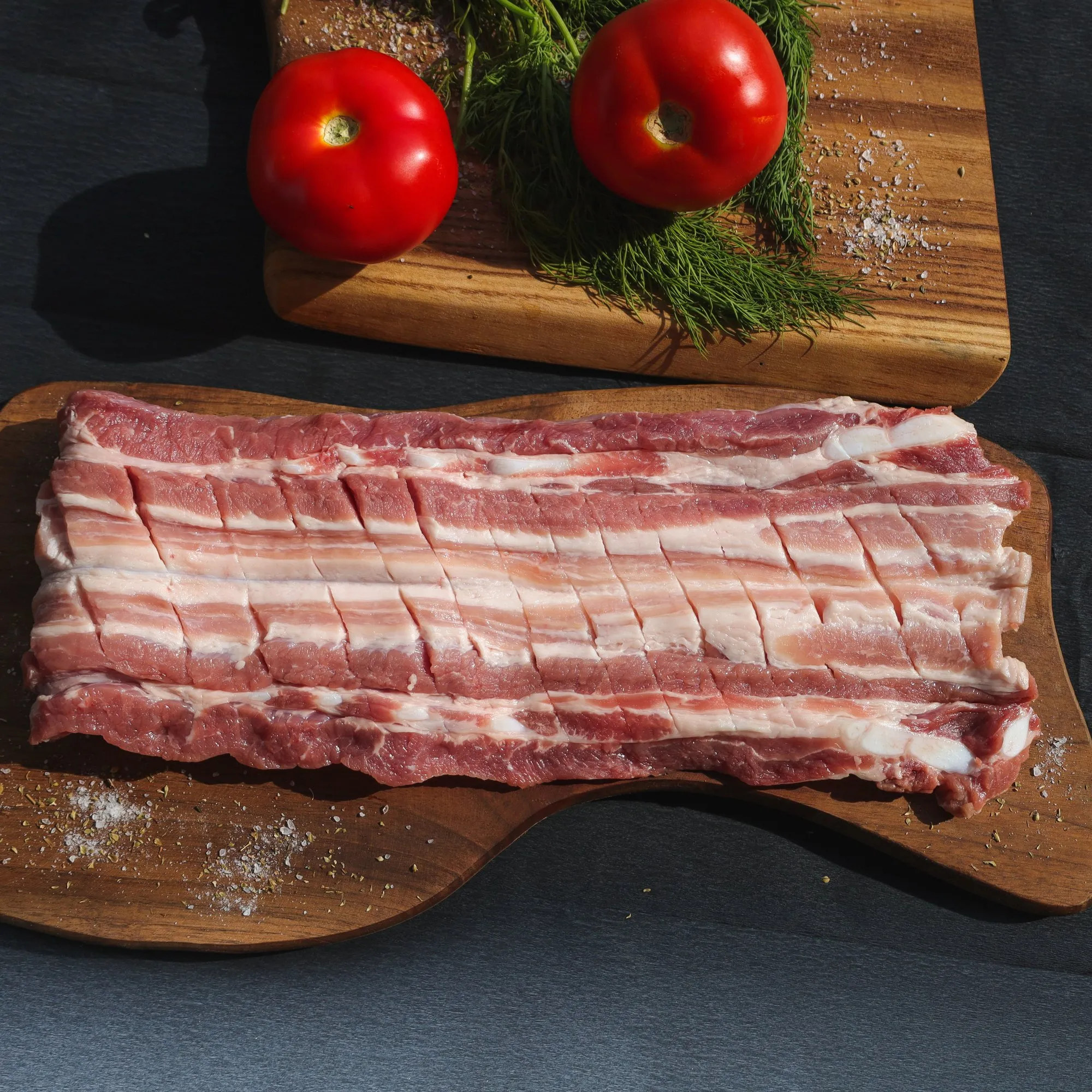 Piept de porc proaspăt, crestat, pe o planșetă de lemn